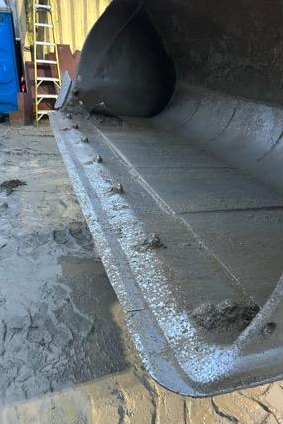 Underside of a rebuilt bucket showing the new wear plate and welds