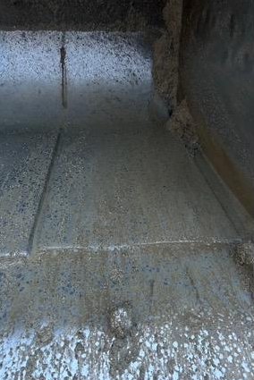 Close-up of a worn cutting edge and weld build-up on a bucket corner
